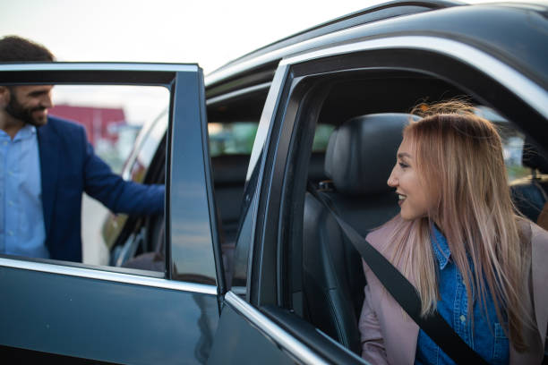 istock Handsome man entering car with friends 1154373376