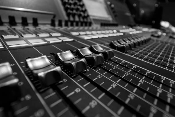 istock Wide angle closeup of Professional Digital Audio  Sound Mixing Control  Console. Silver White Faders and black Graphic control Console 1154373477