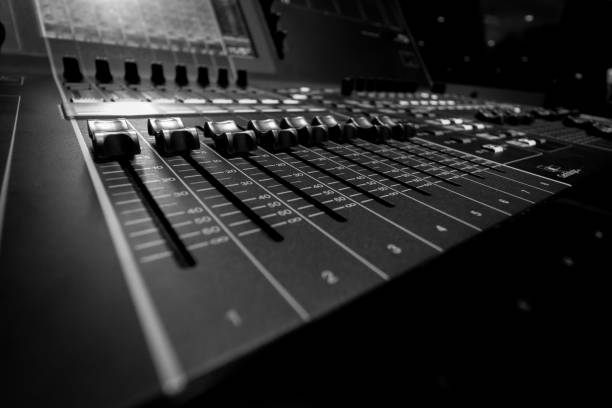 istock Wide angle closeup of Professional Audio Digital Sound Mixing Control Console. Silver White Faders and black Graphic control Console 1154373496