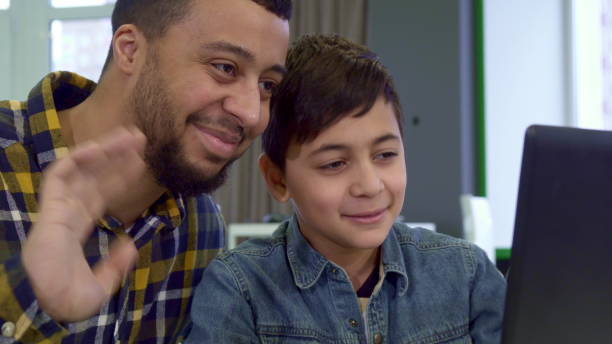 istock Father and son look at the laptop screen 1154373661