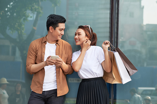 A picture of a couple shopping with smartphone in the city