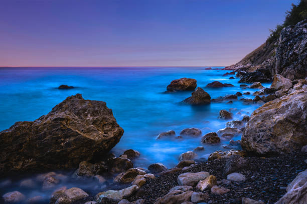 Long exposure image of Dramatic sky seascape with rock in sunset scenery background