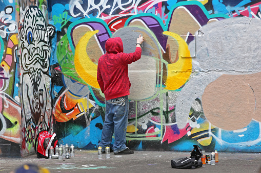 London, United Kingdom - January 26, 2013: Young Graffiti Artist Vandal Spraying Walls With Paint in London, UK.