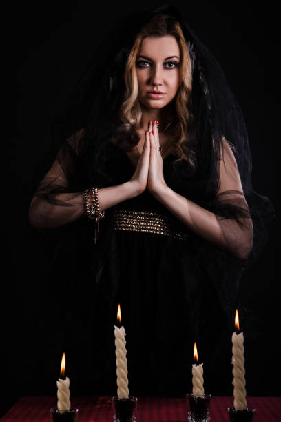 istock Young woman with candles in darkness 1154378536