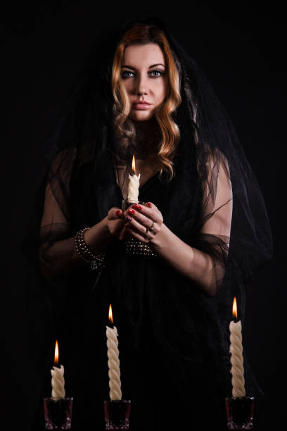 istock Young woman with a candle in darkness 1154378542
