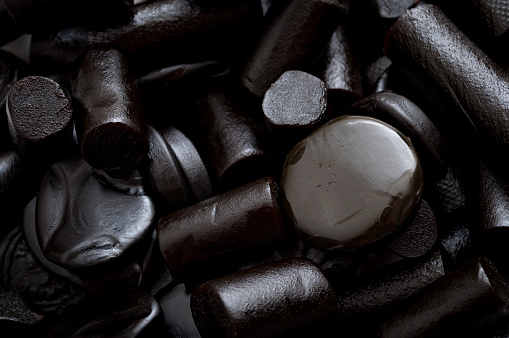 Sugar-based confectionery and sweet candy concept with close up on a pile of black licorice
