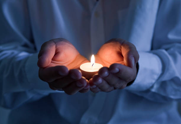 istock Male hands holding a tea candle 1154381728