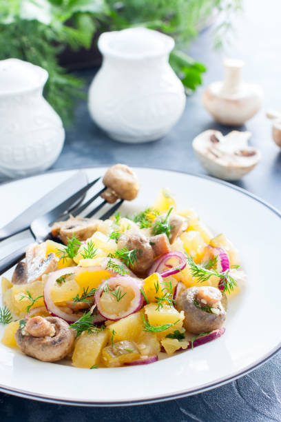 istock Potato salad with marinated champignons on a white plate, selective focus 1154384146
