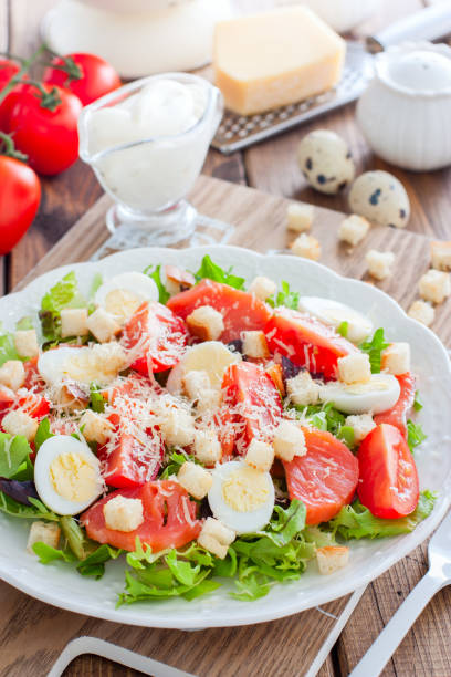 istock Caesar salad with salted salmon on a white plate, selective focus 1154384426