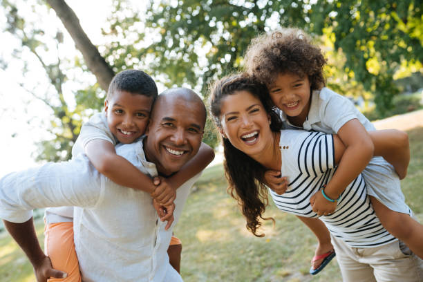istock Parents piggybacking sons in the park 1154387119
