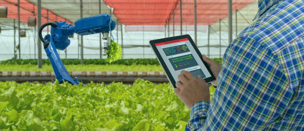 istock iot smart industry robot 4.0 agriculture concept,industrial agronomist,farmer using software Artificial intelligence technology in tablet to monitoring condition and control automatic robotics in farm 1154387310