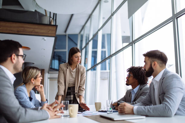 istock Female manager stands addressing team at board meeting 1154388604