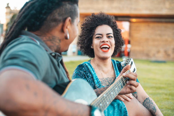 istock Couple playing guitar and singing in public park 1154390118