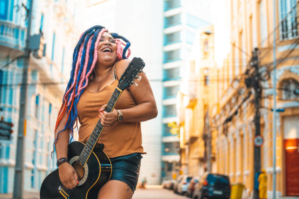 punk-frau, die akustikgitarre spielt - street musician stock-fotos und bilder