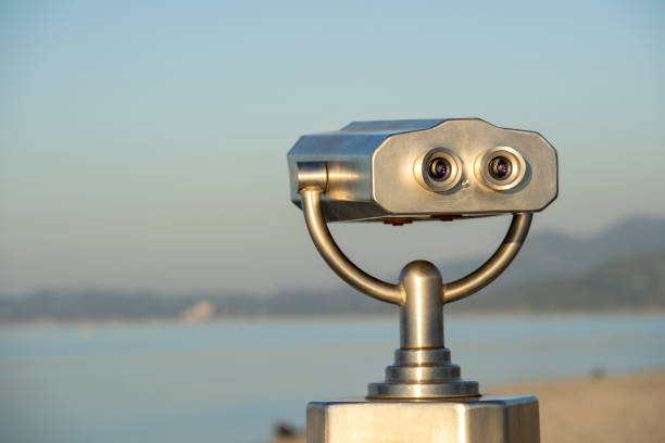 istock Public binocular on sea shore, close up. Coin operated binocular viewer on blurred background of sunset and sea 1154390431