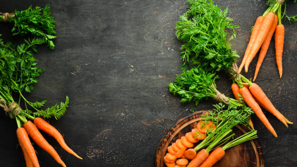 istock Sliced carrots on a wooden table. Top view. Free space for your text. 1154394365