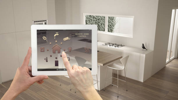 istock Smart remote home control system on a digital tablet. Device with app icons. Minimalist modern bright kitchen in the background, architecture interior design 1154394380