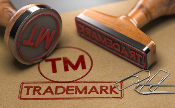Trademark Registration Concept 3D illustration of two rubber stamps with the word trademark and the symbol TM over brown paper background. Trade-mark Registration Concept intellectual property stock pictures, royalty-free photos & images
