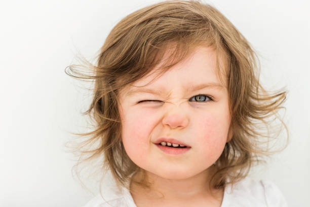 Happy funny baby eyewink isolated on white background Happy funny baby eyewink isolated on white background. Beautiful close portrait of a girl winking with blue eyes blinking stock pictures, royalty-free photos & images