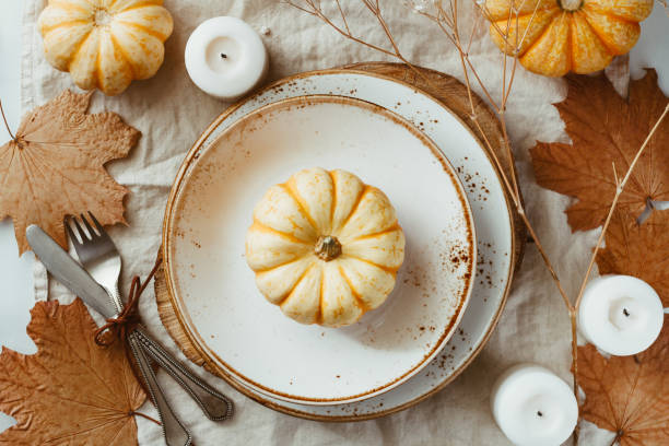 istock Top view on a decorated table setting for Thanksgiving dinner. Autumn ornate, white pumpkin on ceramic plates. 1154396808