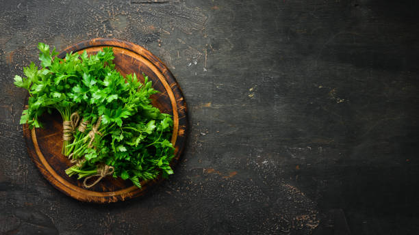 istock Fresh parsley on a wooden background. Top view. Free space for your text. 1154397987