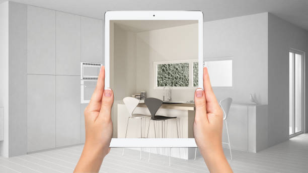 istock Hands holding tablet showing modern white and wooden kitchen, total blank project background, augmented reality concept, application to simulate furniture and interior design products 1154398103