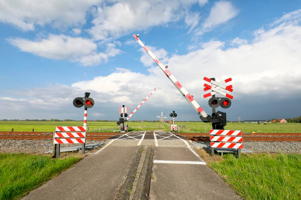afsluiting barriere bij trein rainway kruising en blauwe lucht - trein nederland stockfoto's en -beelden