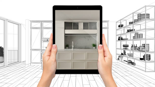 istock Hands holding tablet showing modern white classic kitchen. Blueprint CAD sketch background, augmented reality concept, application to simulate furniture and interior design products 1154398462