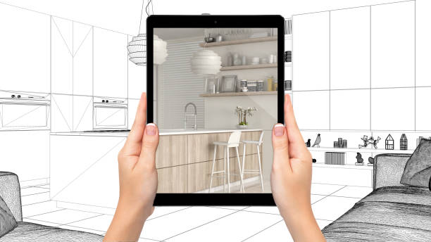 istock Hands holding tablet showing modern white and wooden kitchen. Blueprint CAD sketch background, augmented reality concept, application to simulate furniture and interior design products 1154398466