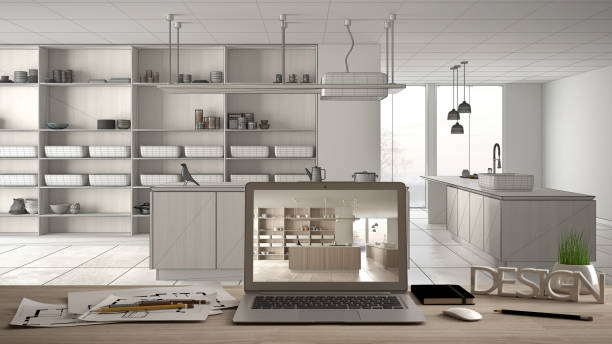 istock Architect designer desktop concept, laptop on wooden work desk with screen showing interior design project, blueprint draft background, modern white kitchen with wooden details 1154398596