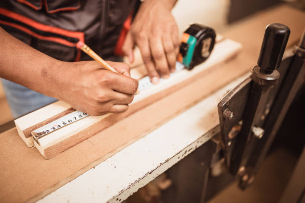 istock Close up of African American carpenter hands on work 1154400402