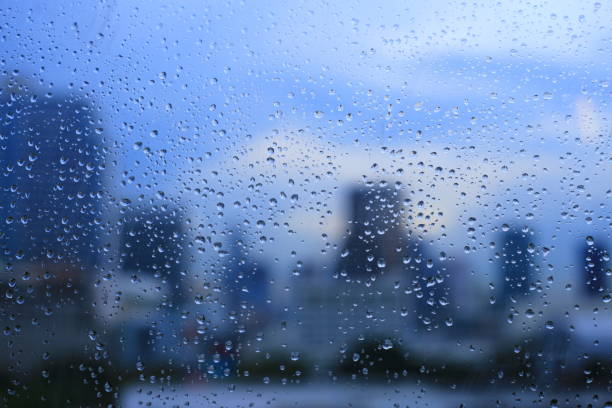 istock office window covered with rain water. water spray on window. after rain traffic, worker stuck in the office concepts. blur urban skyline background. rainy season concepts. 1154402467