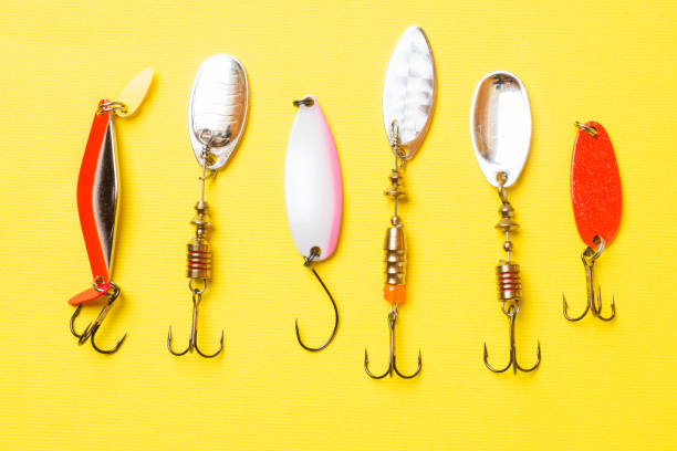 istock Fishing hooks and baits in a set for catching different fish on a yellow background with copy space. Flat lay 1154403806