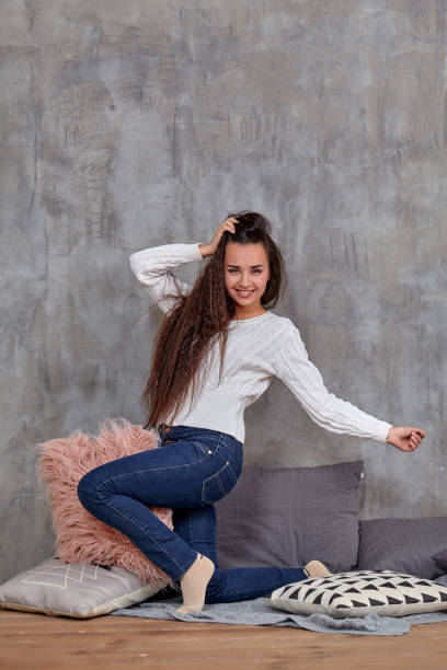 istock Young pretty attractive brunette woman posing before camera sitting on the floor 1154409131