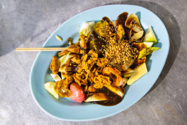 Popular Penang fruit rojak served with prawn paste and groundnuts Popular Penang fruit rojak served with prawn paste and groundnuts, served on table traditional malaysian food stock pictures, royalty-free photos & images