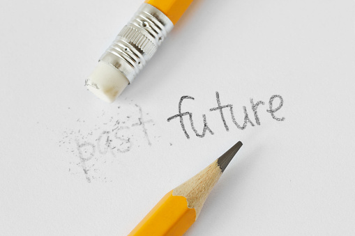 La palabra pasada borrada con un caucho y la palabra futuro escrito con un lápiz sobre papel blanco-concepto del tiempo, limpiando el pasado y construyendo un futuro photo