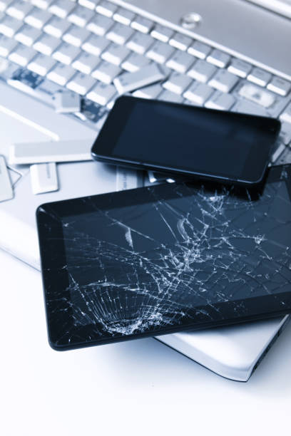 istock A silver laptop with a broken keyboard, tablet with a cracked display and black phone. A close-up picture of part of broken laptop and cracked screen on a tablet. 1154411042
