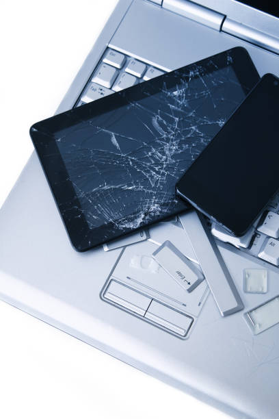 istock A silver laptop with a broken keyboard, tablet with a cracked display and black phone. A close-up picture of part of broken laptop and cracked screen on a tablet. 1154411176