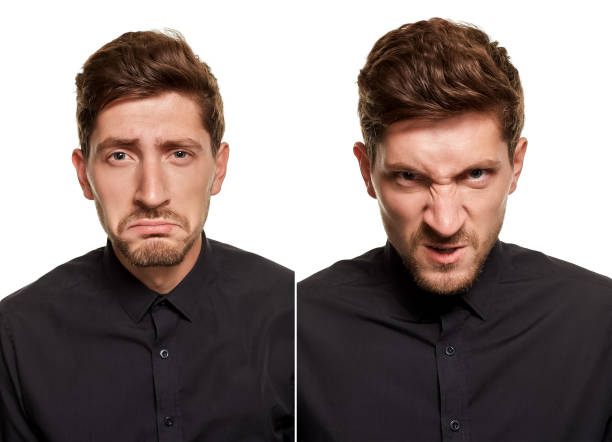 istock Handsome man in a black shirt makes faces, standing against a white background 1154413259