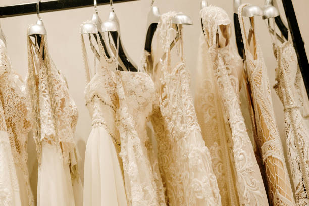 istock Cream wedding dresses hanging on the rack 1154413425