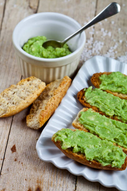 istock Croutons with avocado guacamole on white plate closeup on rustic wooden table. Diet breakfast. 1154414070