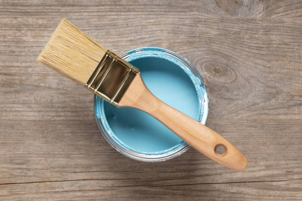 istock Paint brush and can on wooden table 1154415271