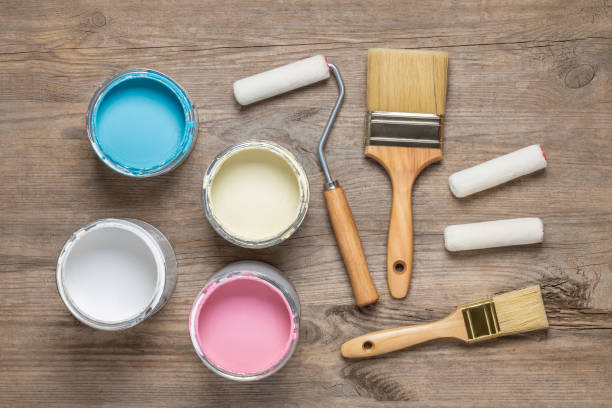 istock Paint brush and cans on wooden table 1154415316