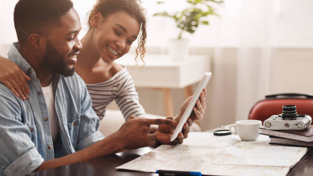 pareja planeando viaje de vacaciones, buscando lugares para visitar - hacer una reserva fotografías e imágenes de stock