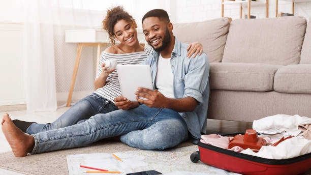 African-american couple planning vacation trip on tablet