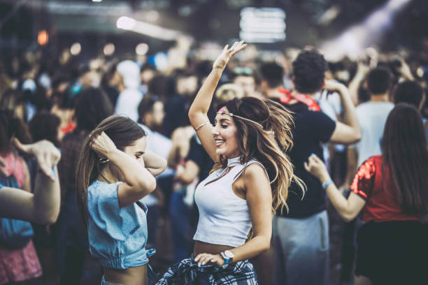 istock Happy female friends having fun while dancing on a music concert. 1154415981