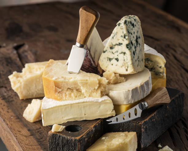Assortment of different cheese types on wooden background.