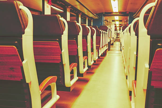 istock Train seats in a train compartment in white optics with wood at a train station at night 1154416338
