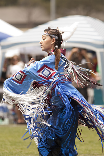 Portrait of a Jingle Dress Dancer in a prairie field with a river background