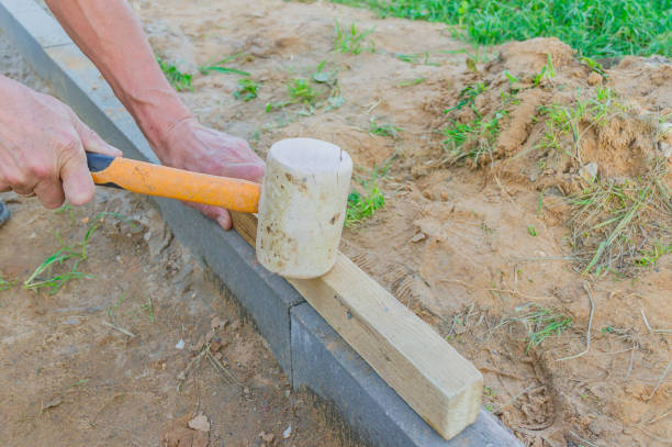 istock Worker laying red and gray concrete paving blocks. Road Paving, construction. 1154417201